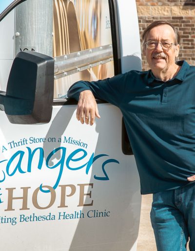 Employee leaning on car window of Donation Truck for Hangers of Hope Thrift Stores Benefiting the Bethesda Health Clinic in Tyler, TX