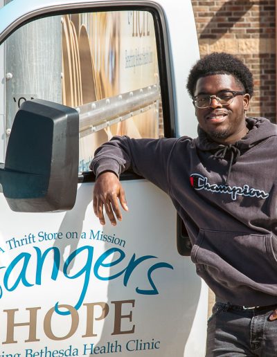 Employee leaning on car window of Donation Truck for Hangers of Hope Thrift Stores Benefiting the Bethesda Health Clinic in Tyler, TX