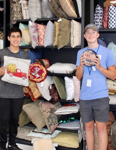 Volunteers holding items in Hangers of Hope Thrift Stores Benefiting the Bethesda Health Clinic in Tyler, TX