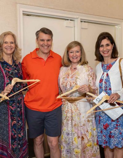 Guests holding Coat Hangers at the Runway for Hope at Hangers of Hope Thrift Stores Benefiting the Bethesda Health Clinic in Tyler, TX